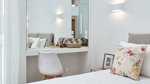 A bedroom with a bed, a chair, a bedside table, a mirror, and a wall-mounted light fixture. - Luxurious Spacious Apt next  Hilton Area (Athens)