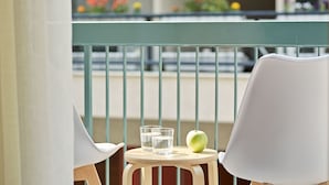 A balcony with a table, two chairs, and a glass of water and an apple. - Luxurious Spacious Apt next  Hilton Area (Athens)