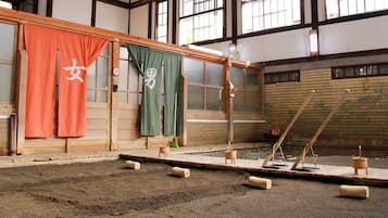 A tatami room with tatami mats, a shoji screen, and a traditional Japanese washbasin.