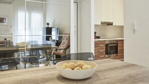 Eine moderne Küche mit Holzausstattung, einem Backofen und einem Essbereich mit Glastisch und Stühlen.