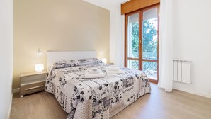 A bedroom with a bed, bedside lamps, a window with a view, and a radiator. - Padova - Via Faggin 47A (Padova)
