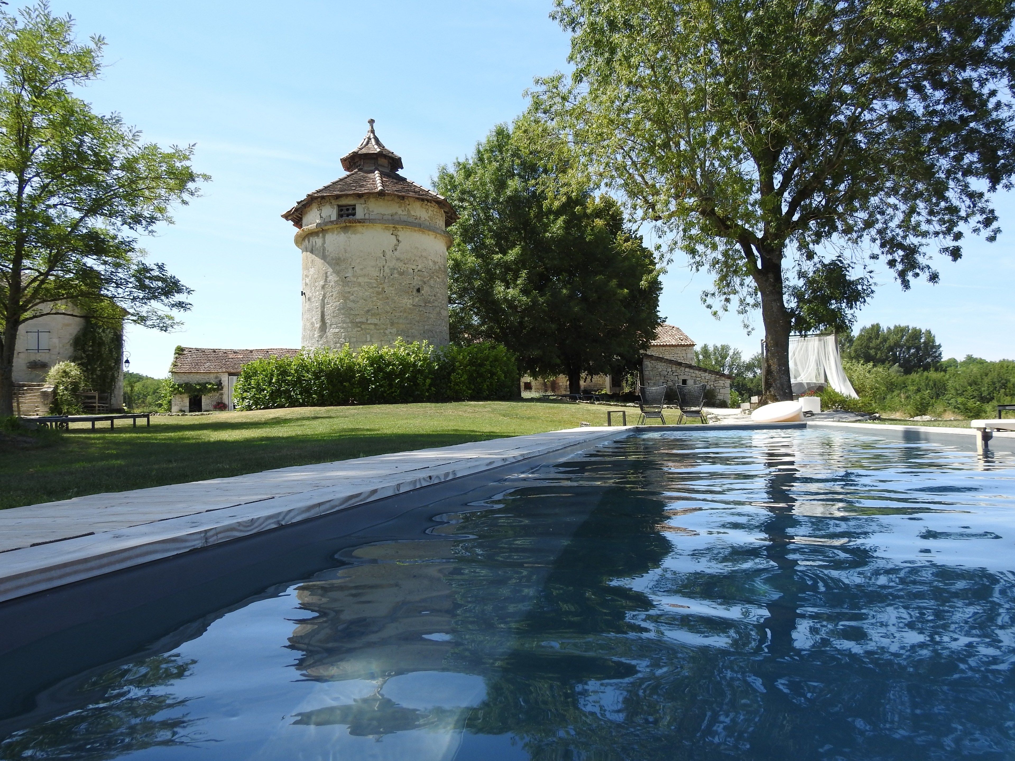 A swimming pool with a stone tower in the background.