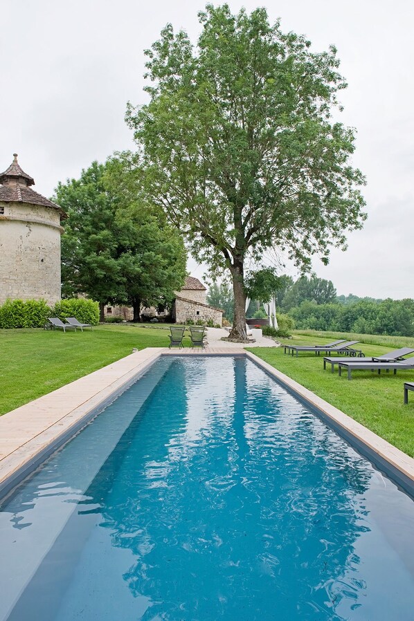 A rectangular swimming pool with a clear blue water surface, surrounded by a wooden deck. - Domaine de L'Isle Basse (Fontanes)