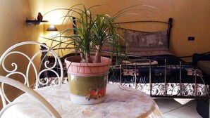A bedroom with a bed, a potted plant on a table, a window, and a lamp. - Bed & Breakfast Monti e Mare (Lanusei)