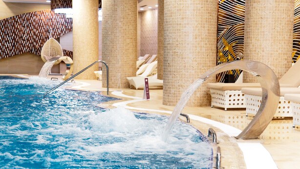 A hot tub with water jets, surrounded by lounge chairs and a patterned wall. - Boutique Hotel Health Club&Spa GrandPrix (Astana)
