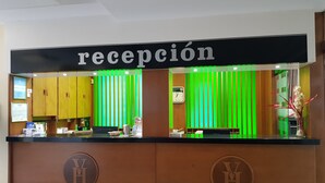 A reception desk with a sign reading "recepción" and a clock above it. - Hotel Veracruz (Don Benito)