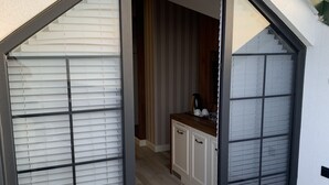 A modern kitchen with white cabinets and a wooden countertop. - White Golden Suite Hotel (Trabzon)