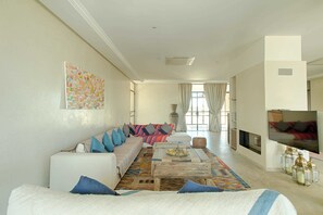 Exclusive-Villa, eigener Pool, Bergblick | Wohnbereich | 55-Zoll-Flachbildfernseher mit Satellitenempfang, Smart-TV, Kamin