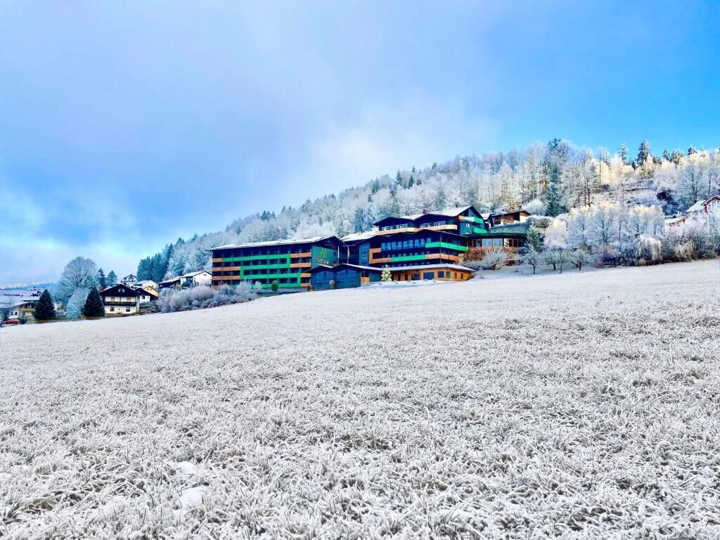 A multi-story building with a ski resort in the background.