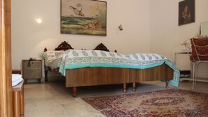 Un dormitorio con una cama de madera, una mesita de noche, una silla y un cuadro en la pared.