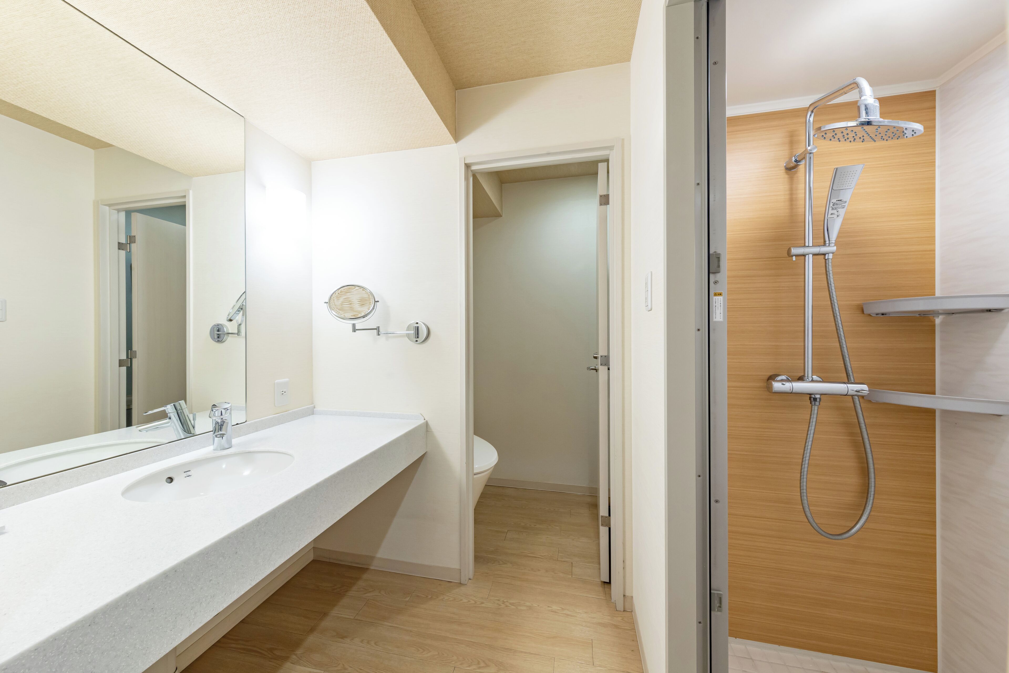 Ein modernes Badezimmer mit großem Spiegel, Waschbecken, Toilette und Dusche.