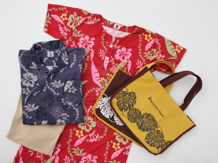 A red floral shirt, a blue floral shirt, a beige shirt, and a yellow tote bag with a floral design.