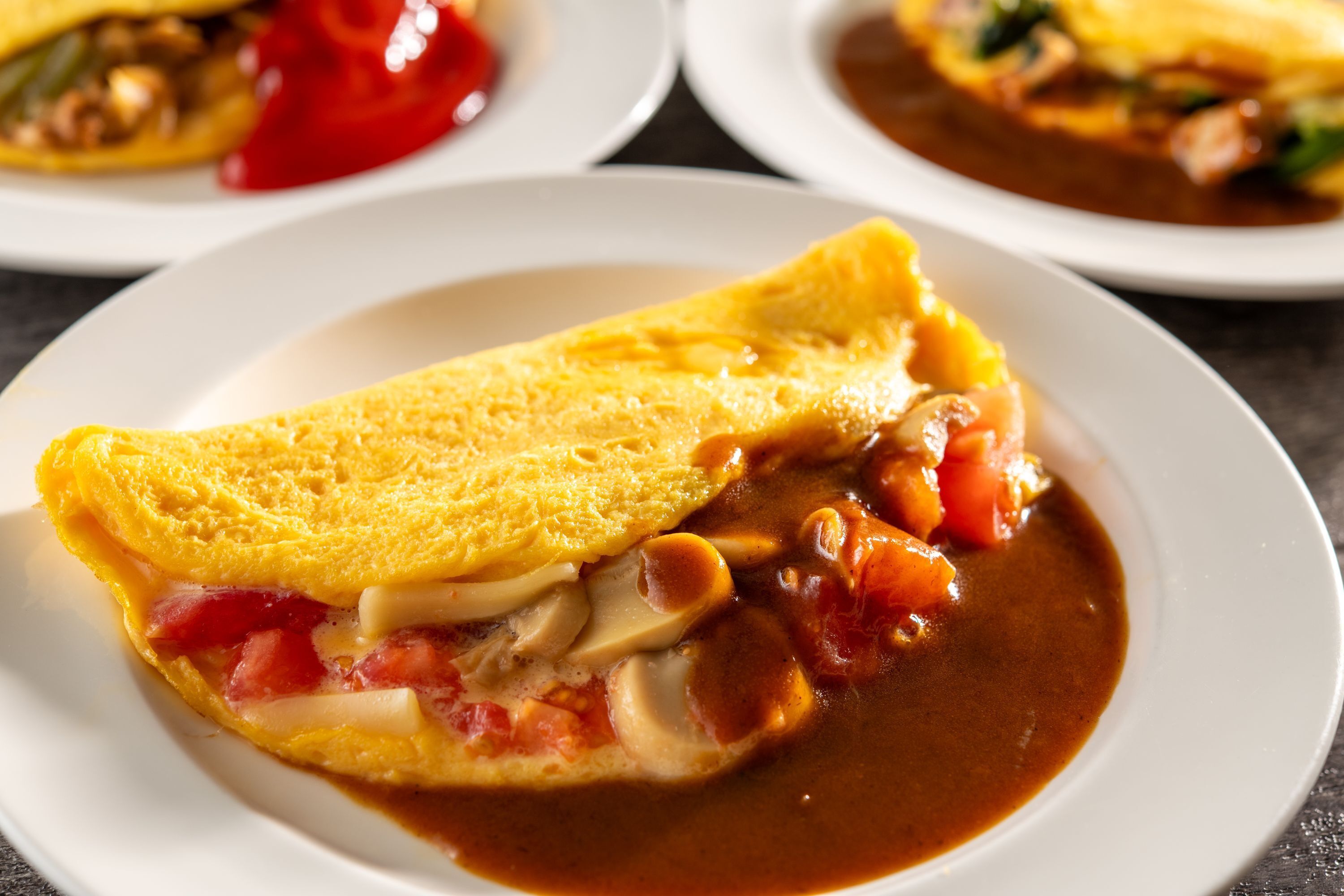 Un plato con una tortilla enrollada y salsa de tomate.