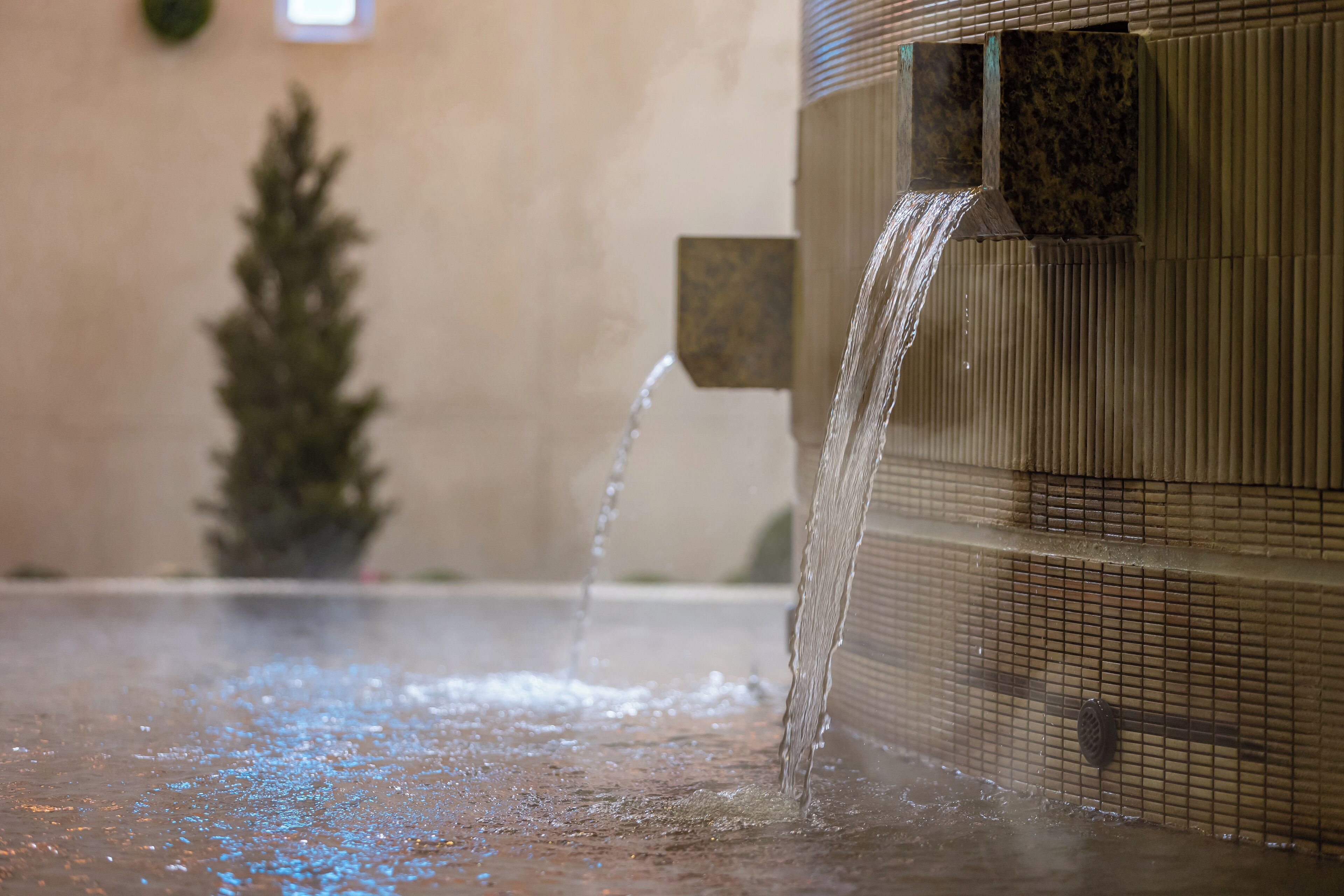 A water feature with multiple streams of water flowing into a basin.