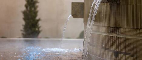 A water feature with multiple streams of water flowing into a basin.