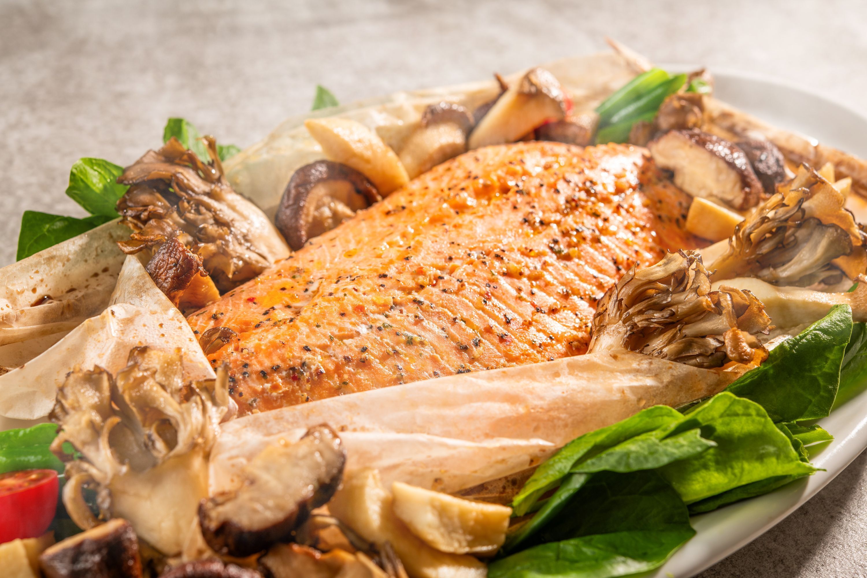 A plate with a roasted fish, mushrooms, and greens.