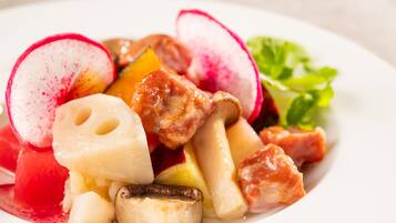 A plate of food with various vegetables and a slice of radish.