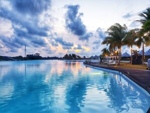 Una piscina al aire libre, sillones reclinables de piscina