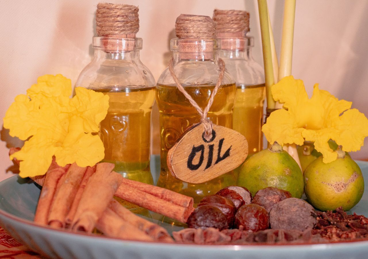 Tres botellas de vidrio con tapones de corcho, cada una con una etiqueta de madera que dice 'OIL'.
