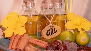 Tres botellas de vidrio con tapones de corcho, cada una con una etiqueta de madera que dice 'OIL'.