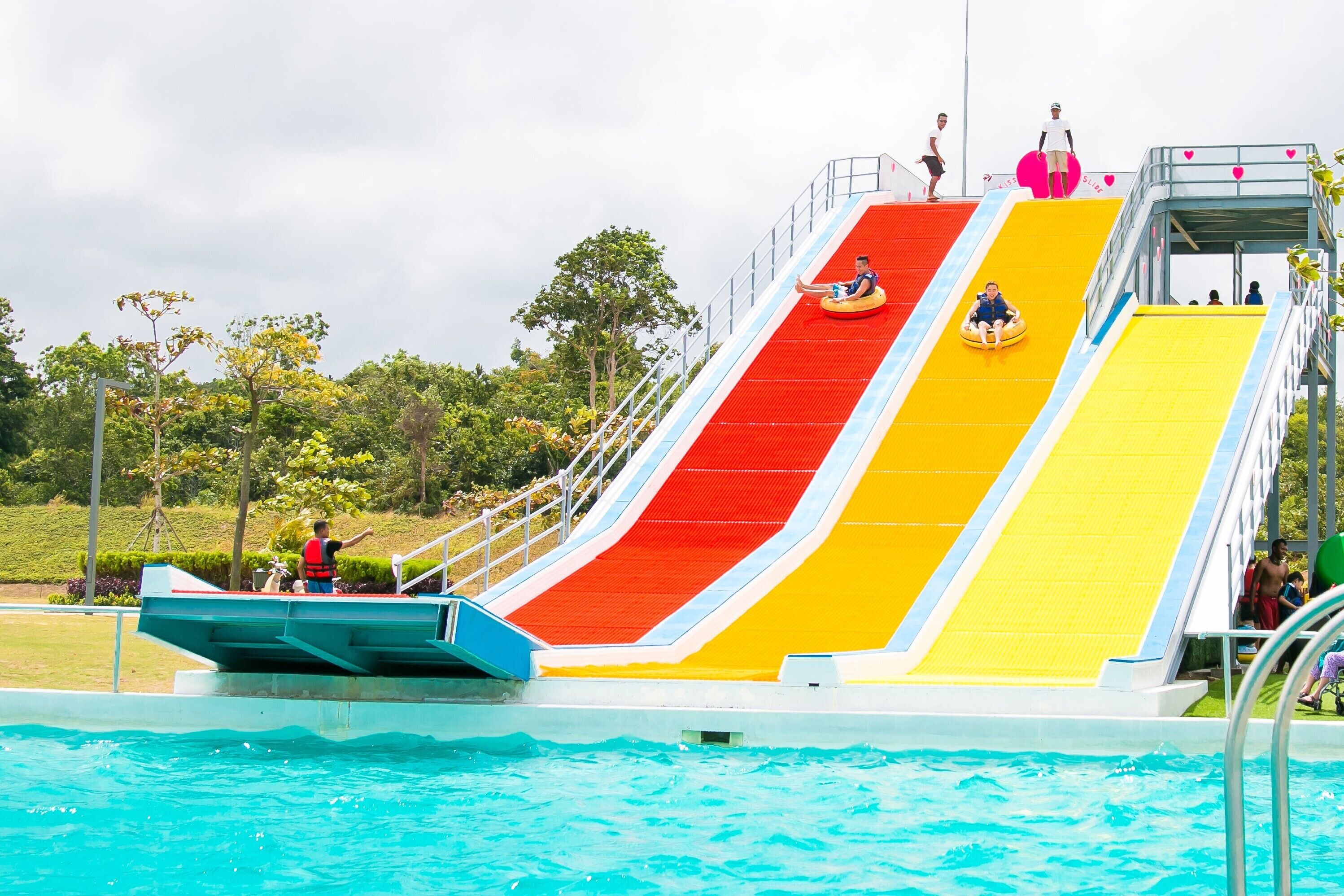 A multi-colored water slide with a pool at the bottom.