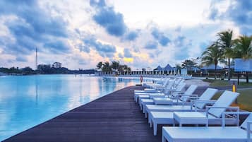 Una piscina al aire libre, sillones reclinables de piscina