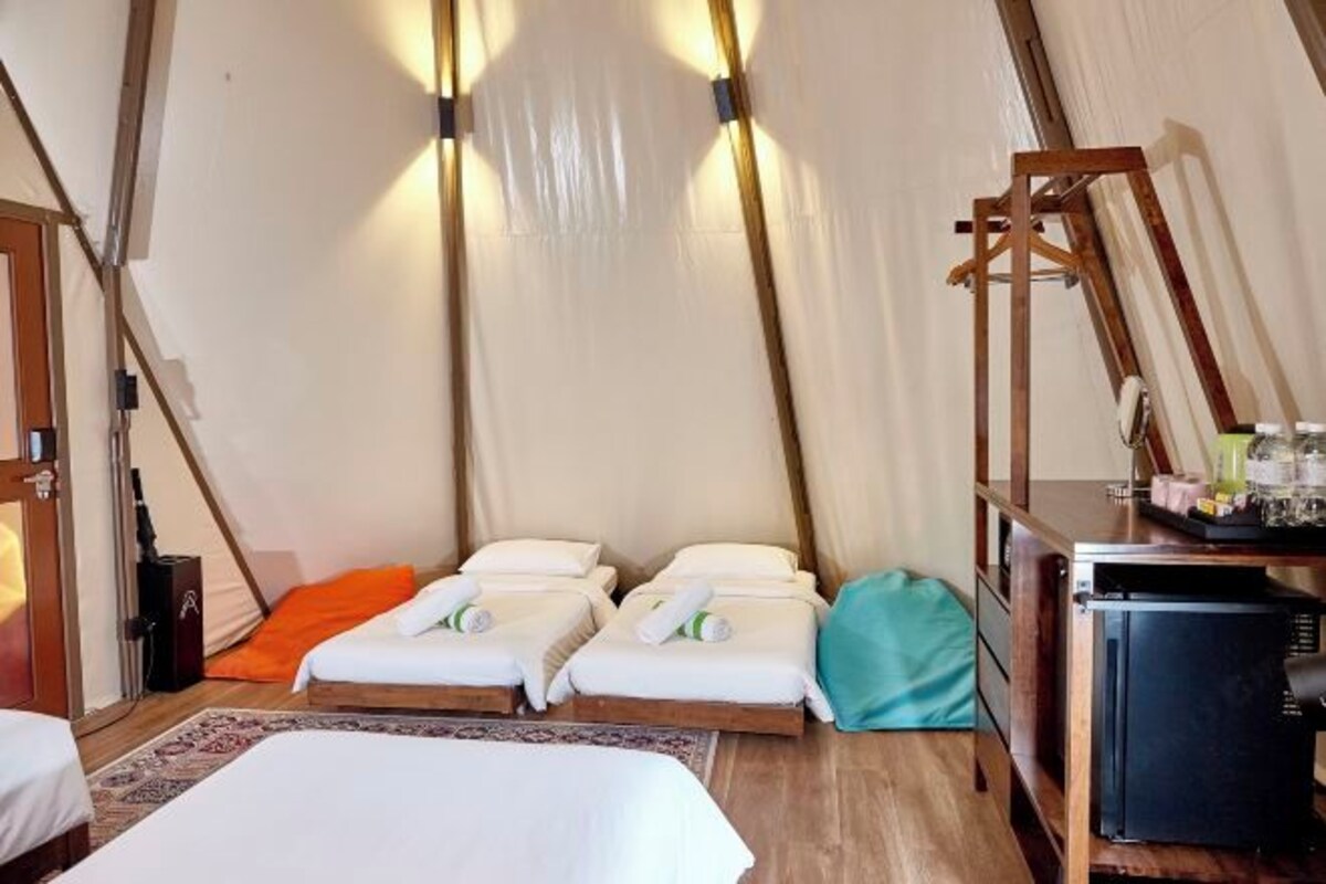 A tent with two beds, a desk, and a chair.