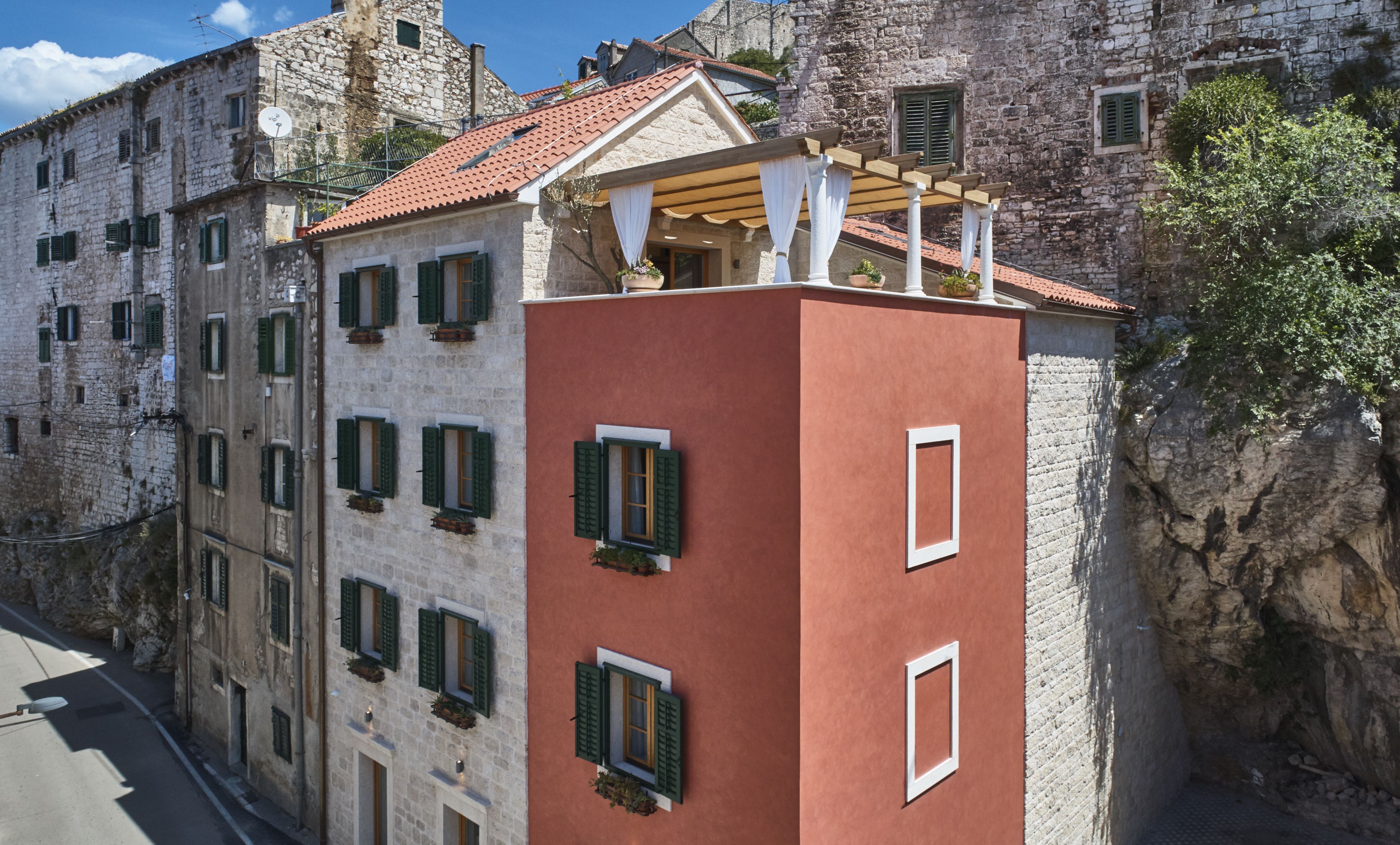 Un edificio histórico con múltiples ventanas y fachada roja.