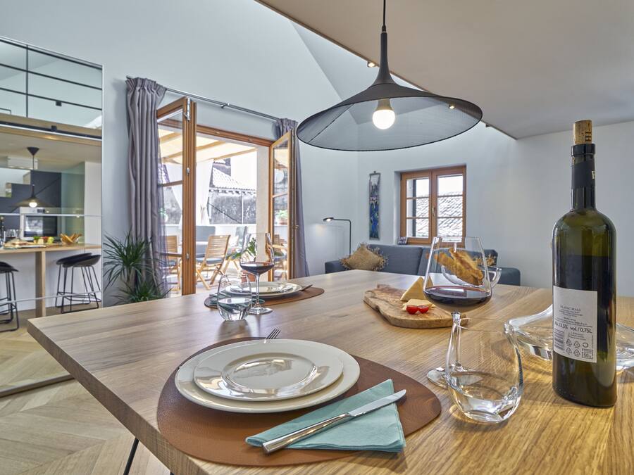 A modern kitchen with a dining area, wooden countertops, and a large window.