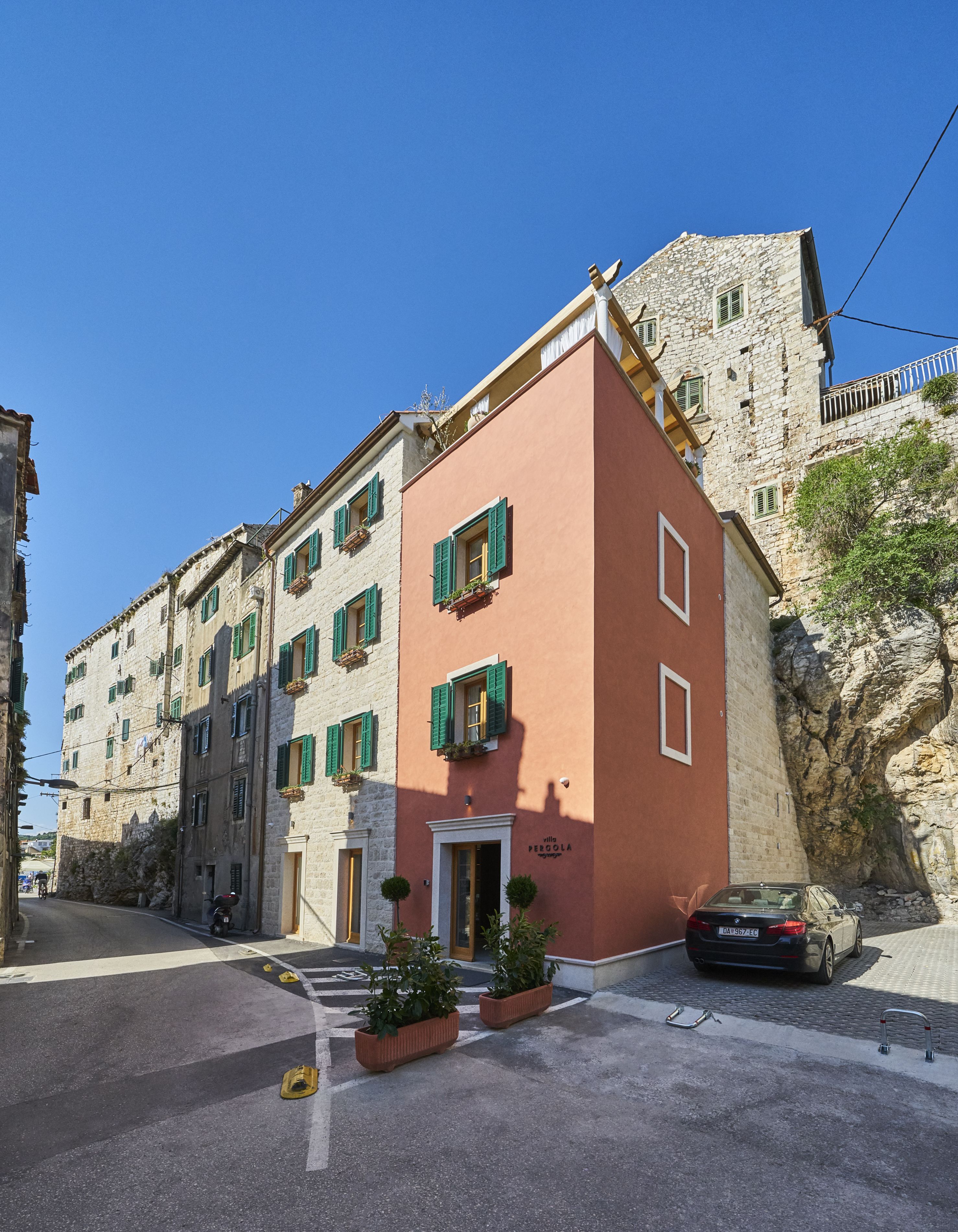 A building with a stone facade and a pink-colored section.
