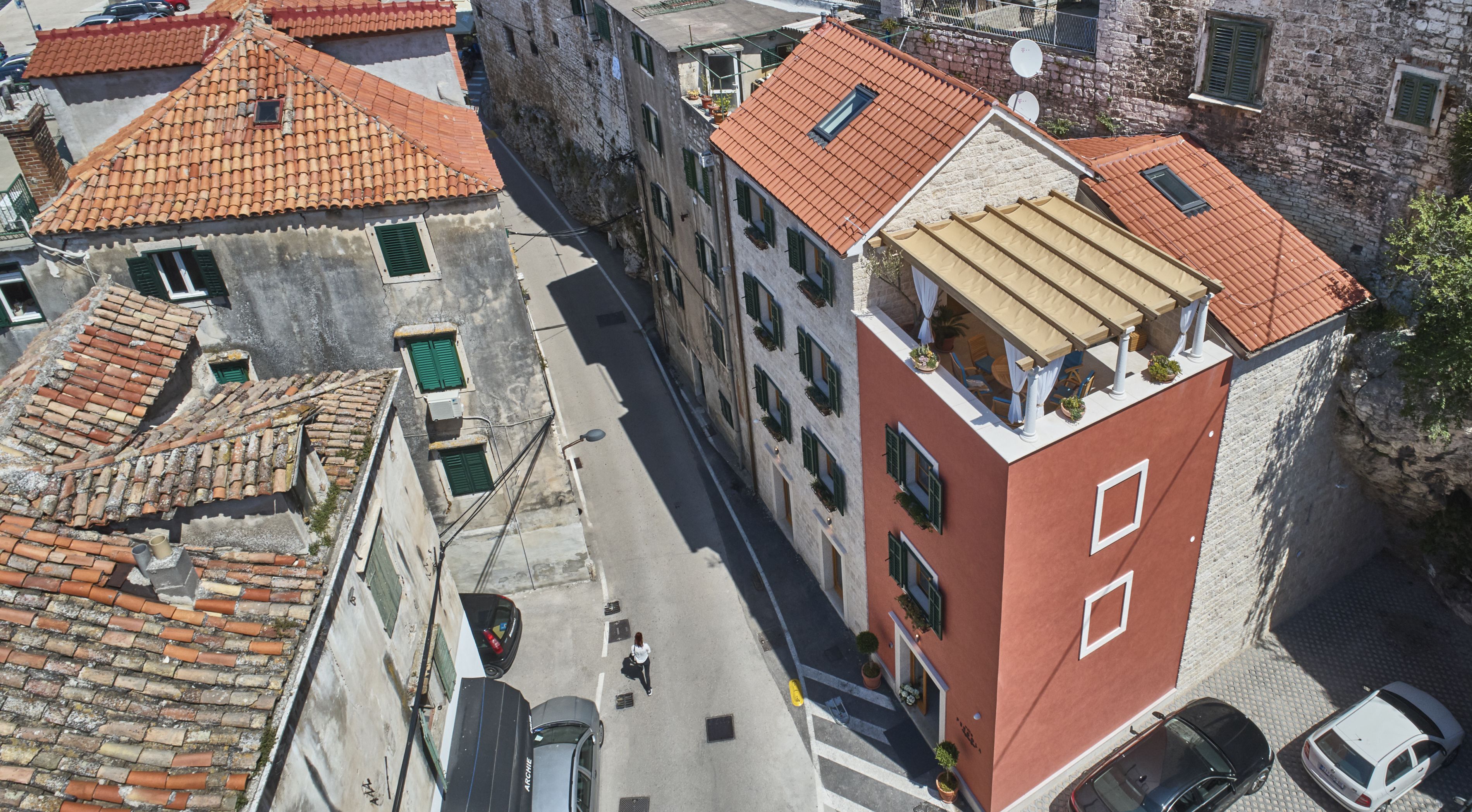 En bygning med flere etager, rød facade og terracotta tagsten.