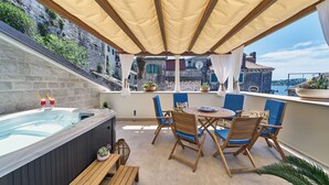 A rooftop terrace with a hot tub, wooden furniture, and potted plants. - Villa Pergola (Sibenik)