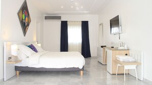 Una habitación de hotel moderna con cama, escritorio, silla y televisión.