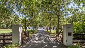 A pathway flanked by trees and wooden gates, leading to a building labeled '421 Parcels'.