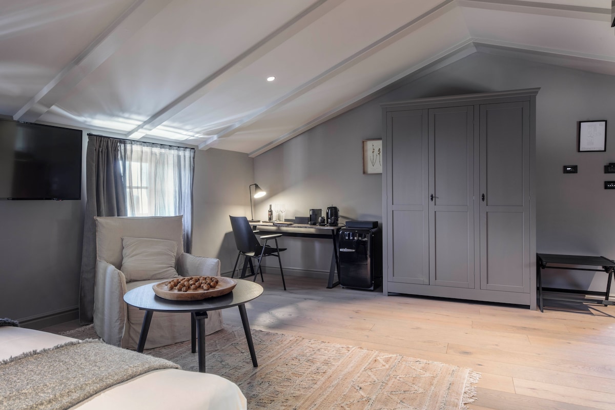 Une chambre de style loft moderne, dotée d’un grand lit, d’un bureau et d’une kitchenette.