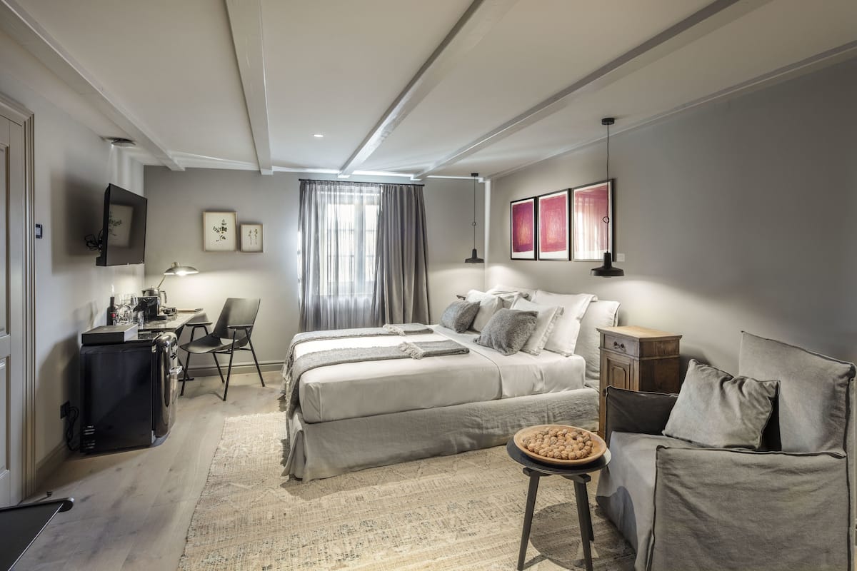 Une chambre à coucher moderne avec un grand lit, un bureau et une chaise.