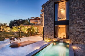 A modern house with a swimming pool, outdoor seating, and a stone facade. - San Canzian Hotel & Residences - Small Luxury Hotels of the World (Buje)
