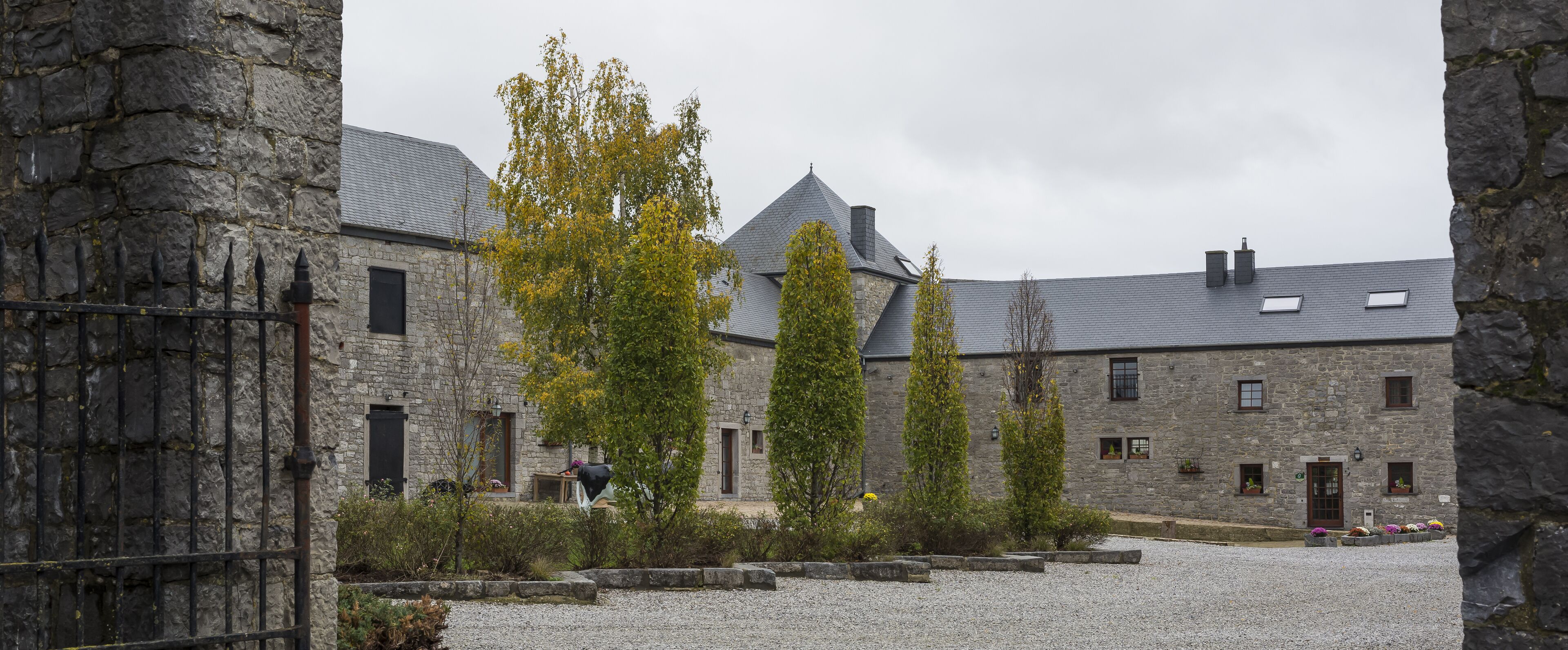 Ein Steinhaus mit Innenhof, mit Kiespflaster und einem Metallgitter.