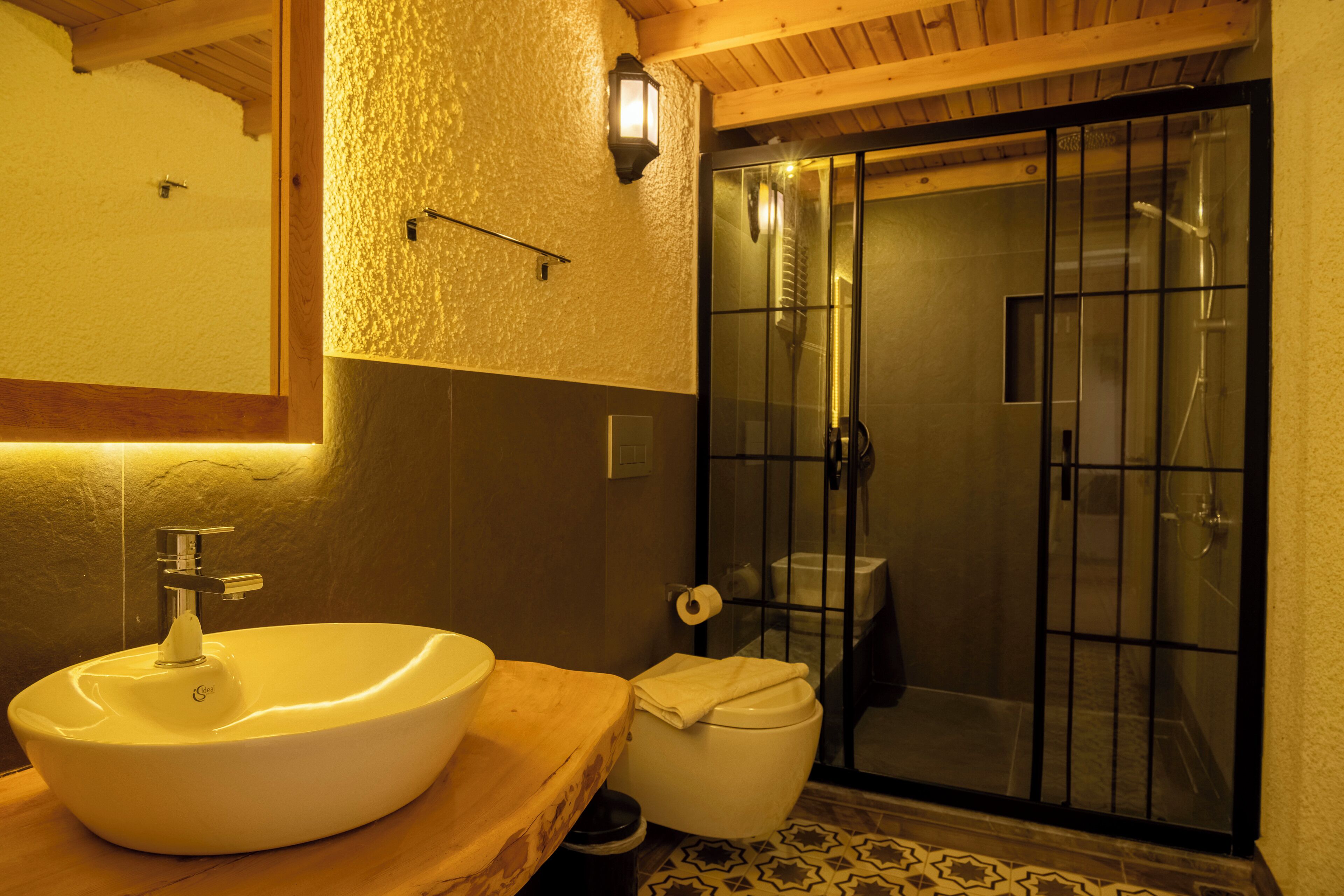 Ein Badezimmer mit weißem Waschbecken, WC und einer Duschkabine.
