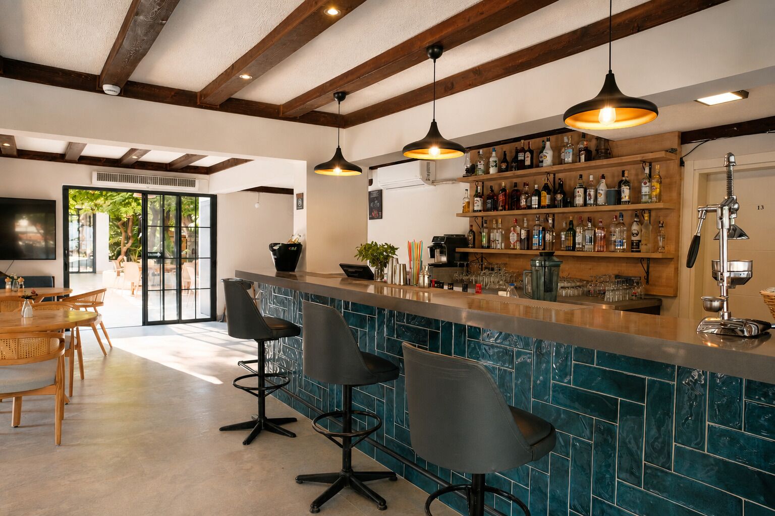 A bar area with a tiled backsplash, wooden ceiling beams, and a variety of bottles on shelves.
