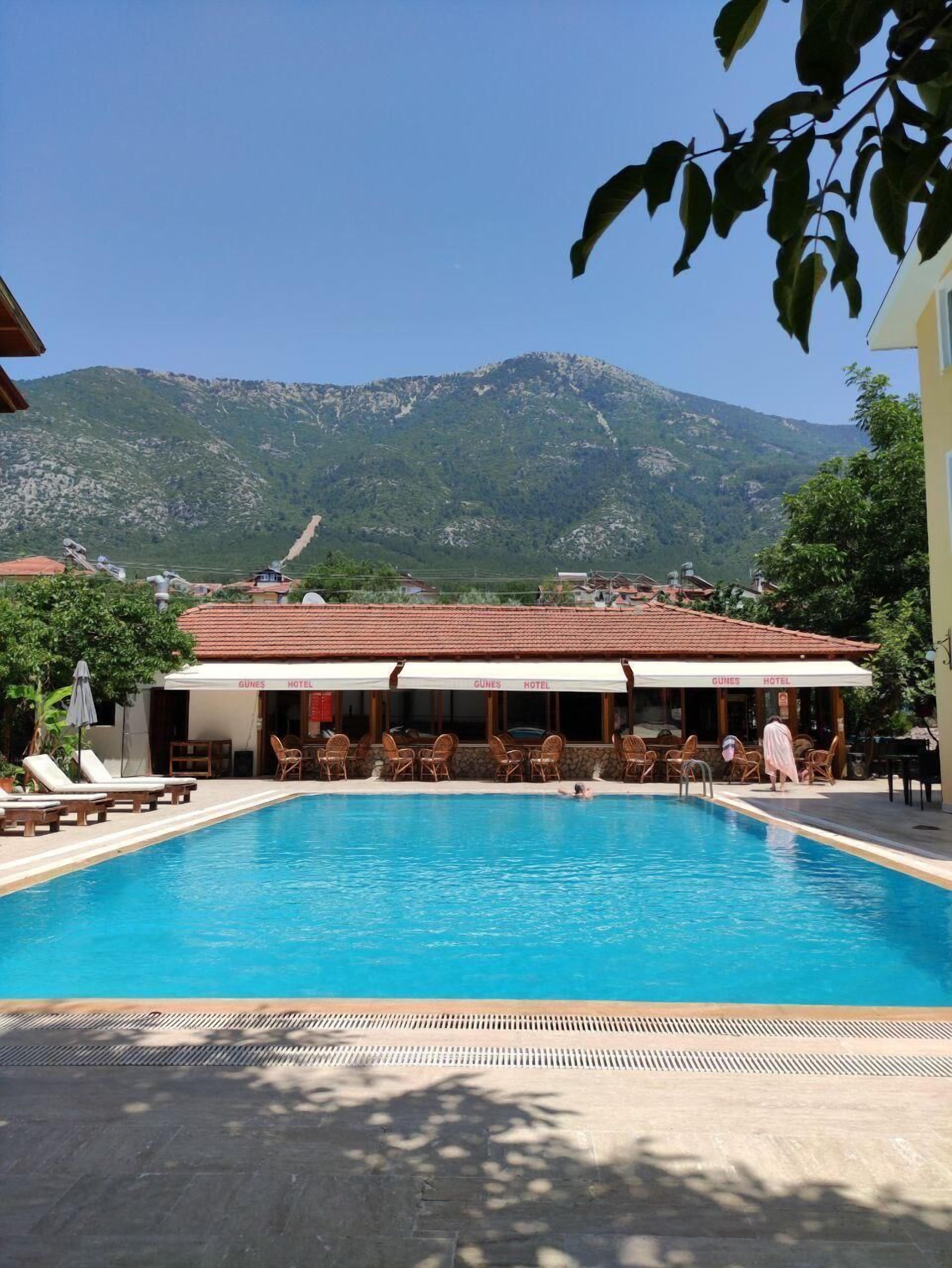 حمّام سباحة خارجي موسمي، مظلات على حمّام السباحة، مقاعد للتشمس