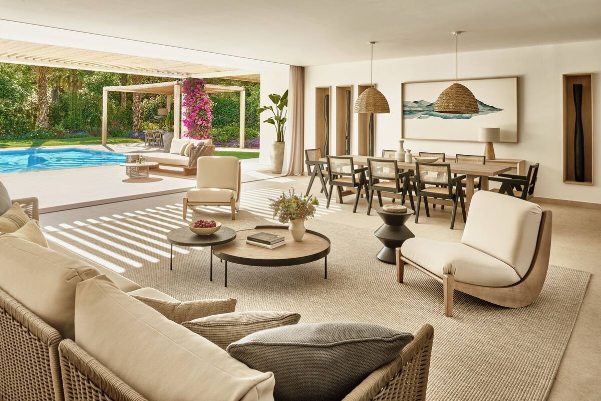 A modern living room with a pool, outdoor seating, and a dining area.
