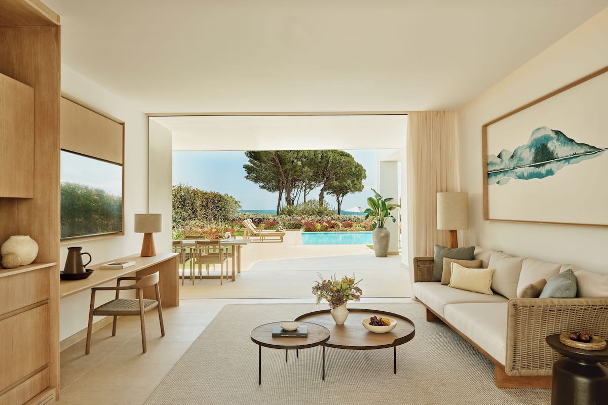 A modern living room with a view of a pool and outdoor seating.
