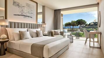 Habitación de hotel moderna con una cama grande, un escritorio y vistas a un campo de golf.