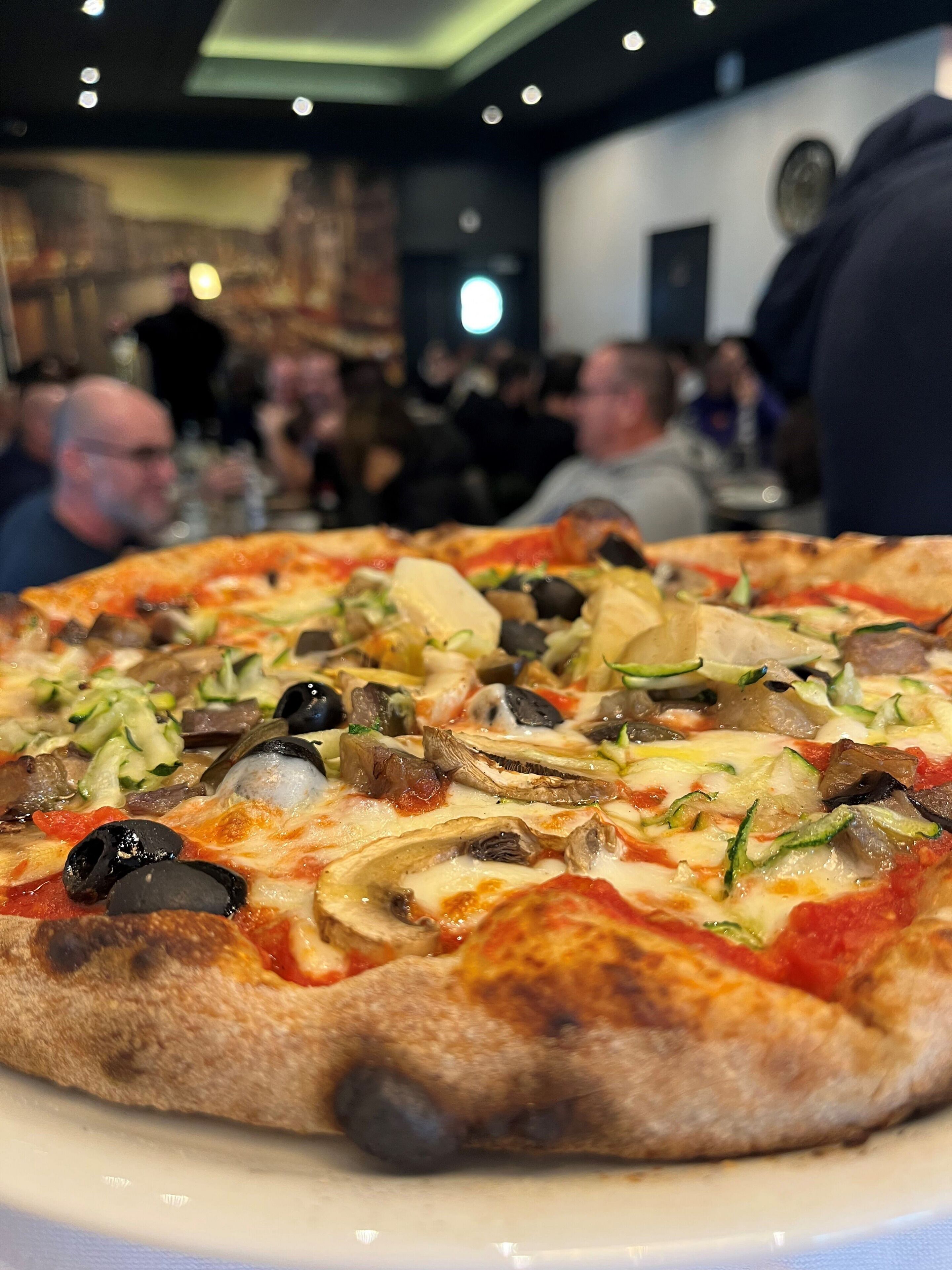 A pizza with various toppings on a white plate.