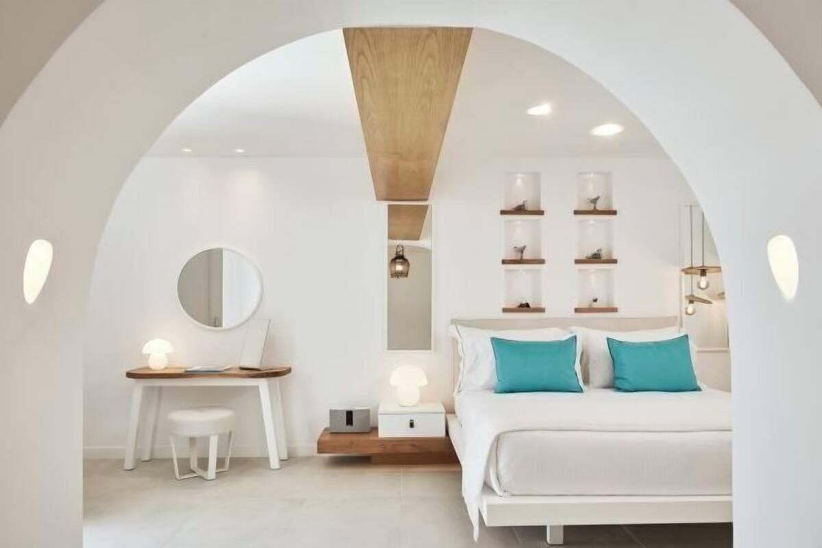 Une chambre à coucher moderne avec un lit, des tables de chevet, un bureau et des étagères.
