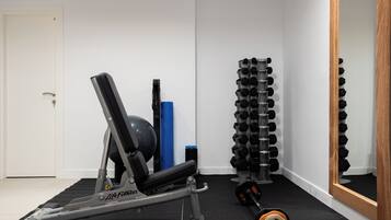 Un gimnasio con equipo de ejercicio, un espejo y una puerta.