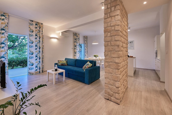 Familiehus, flere senger, hageutsikt | Oppholdsområde | En 120-centimeters Flatskjerm-TV med Parabol-TV samt TV og peis