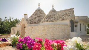 Un edificio de piedra con techo de tejas y fachada blanca.