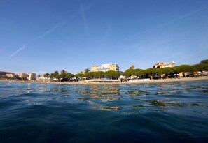 A waterfront view with buildings, palm trees, and a bridge. - Hotel Mayola (San Bartolomeo al Mare)